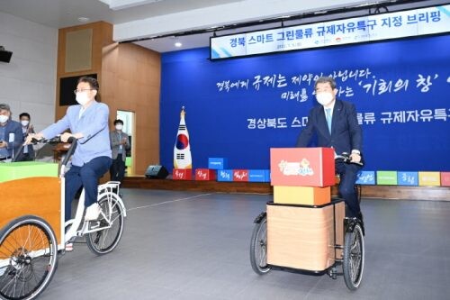 김천시 스마트그린물류 특구지정식에서 물류 자전거를 타고 있는 김충섭 김천시장(우측)