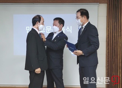 정동균 양평군수가 민주고문 위촉식에서 민주당 배지를 달아주고 있다.