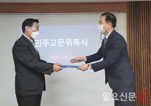 최재관 지역위원장이 민주고문 위촉장을 전달하고 있다.