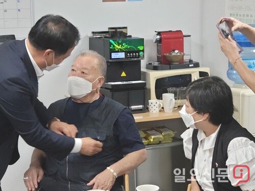 정동균 양평군수가 민주고문에게 민주당 배지를 달아주고 있다.