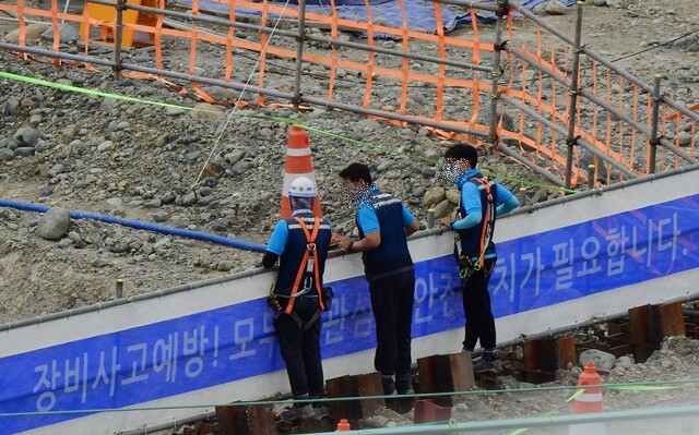 두산건설 현장직원들이 마스크, 안전모, 안전대를 착용하지 않고 공사장을 누비는 모습.