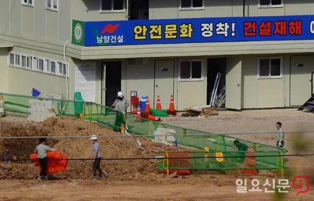 '안전문화 장착'이라고 적힌 현수막 아래에서 남양건설 작업자가 안전모를 미착용한 채로 작업하는 모습.