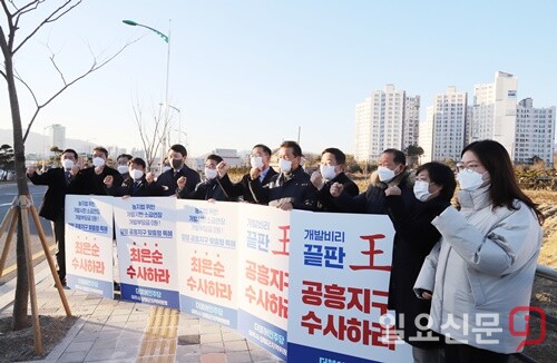 더불어민주당 경기도당 박정 위원장 등이 지난 13일 공흥지구 아파트(사진 뒤) 인근에서 ‘최은순 수사하라’ 는 등의 손팻말을 들고 특혜의혹 수사를 촉구했다.