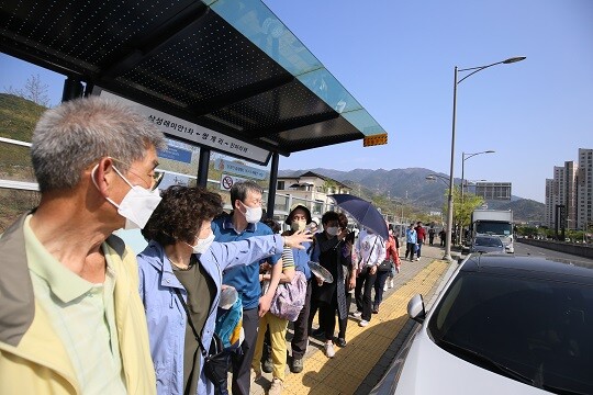 정부가 일상회복을 예고한 가운데 봄과 맞물려 활기가 더해지고 있다. 정류장에서 버스를 기다리는 시민들. 사진=남경원 기자