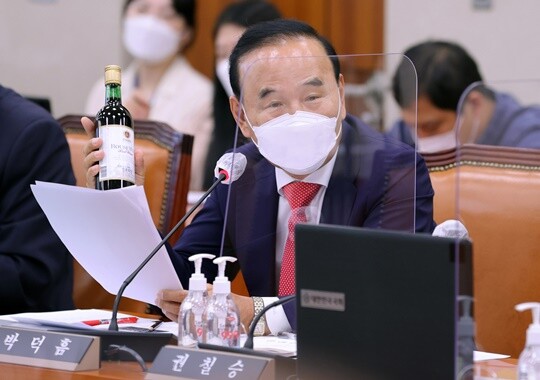 박덕흠 무소속 의원이 2021년 10월 15일 국회에서 열린 농림축산식품해양수산위원회의 농협중앙회 등에 대한 국정감사에서 원산지가 스페인인 진로포도주를 들어 보이고 있다. 박 의원은 이해충돌 논란으로 2020년 9월 국민의힘을 탈당했다가 2021년 12월 복당했다. 사진=일요신문DB