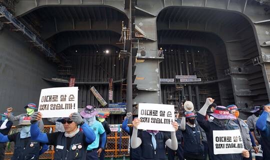 파업당시 경남 거제시 아주동 대우조선해양 옥포조선소 내 독에서 파업 중인 하청지회(앞 구호· 독 왼쪽)와 파업 철회를 촉구하는 대우조선해양 직원(오른쪽 상단)이 벽 하나를 두고 각 농성을 벌였던 모습. 사진=연합뉴스