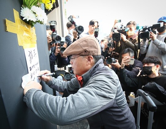 30일 오후 한 시민이 서울 용산구 이태원 핼러윈 축제 압사 사고 현장에 희생자들을 애도하는 추모의 글을 쓰고 있다. 사진=임준선 기자