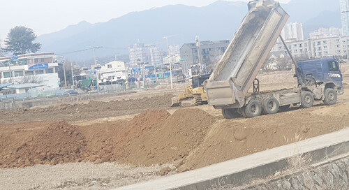 청정 양평군 일대에 출처 불명한 흙이 농지에 대량 성토되면서 농지 훼손과 환경오염, 농로 훼손 피해가 예상되고 있어 대책마련이 시급하다는 지적이다. 사진은 강상면 교평리 소재 농지에 인허가 없이 25톤 트럭과 중장비로 불법 성토하는 현장. 사진=김현술 기자