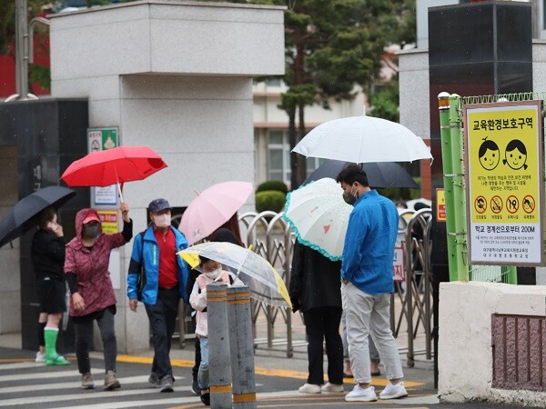 14일 대구교육청이 대구서대구초, 황금초, 대덕초, 구지초등학교 4곳을 '늘봄학교'로 최종 선정했다고 밝혔다. 사진은 비오는 날 한 초등학교에서 우산을 들고 아이를 기다리는 학부모의 모습. 사진=남경원 기자