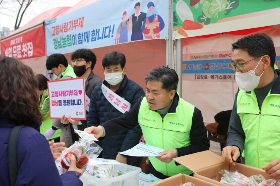 NH농협은행 경남본부 조근수 본부장(가운데) 고향사랑기부제를 홍보하며 농산물을 나눠주는 모습. 사진=경남농협 제공