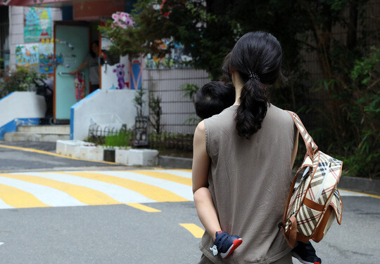 서울의 한 아파트 단지에서 한 엄마가 아이를 안고 어린이집으로 향하고 있다. 사진=연합뉴스