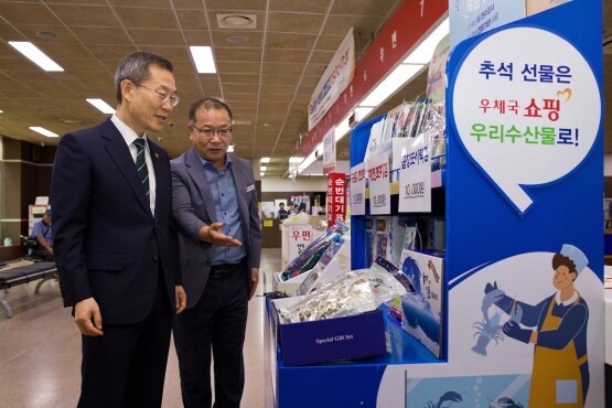 이종호 과학기술정보통신부 장관이 14일 부산우체국을 방문해 우체국 창구에서 판매 중인 우체국쇼핑 우리 수산물을 구매하고 있다. 사진=부산지방우정청 제공