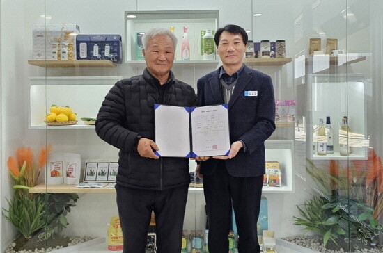 ‘거제시 로컬푸드 인증’ 1호 농가로 강신영(왼쪽)씨 농가를 배출하고 기념 촬영을 가졌다. 사진=거제시 제공