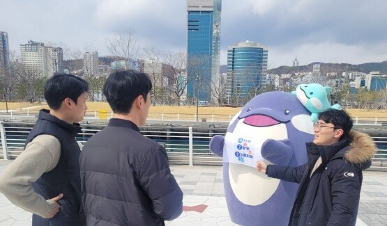 북항 재개발 친수공원에서 걷기 챌린지에 참여한 직원들을 대상으로 BPA 마스코트 해범이가 건강한 생활습관을 홍보하고 있다. 사진=부산항만공사 제공