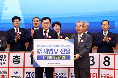 박몽룡 APEC경주유치범시민추진위원장(오른쪽)이 주낙영 시장에게 100만 서명운동 서명부를 전달하고 있다. 사진=경주시 제공