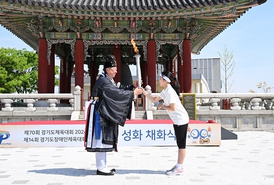 김경일 파주시장이 23일 첫 번째 성화주자인 육상 꿈나무인 교하중학교 장한나 양에게 전달하고 있다. 사진=파주시 제공