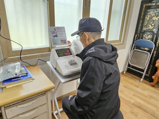 경로당을 방문한 어르신이 혈압측정기를 사용하는 모습. 사진=기장군 제공