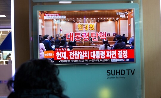 2017년 3월 10일 서울역 대합실에 비치된 TV에서 헌법재판소의 박근혜 대통령 탄핵 인용 선고가 생중계되자 시민들이 모여 시청하고 있다. 사진=이종현 기자