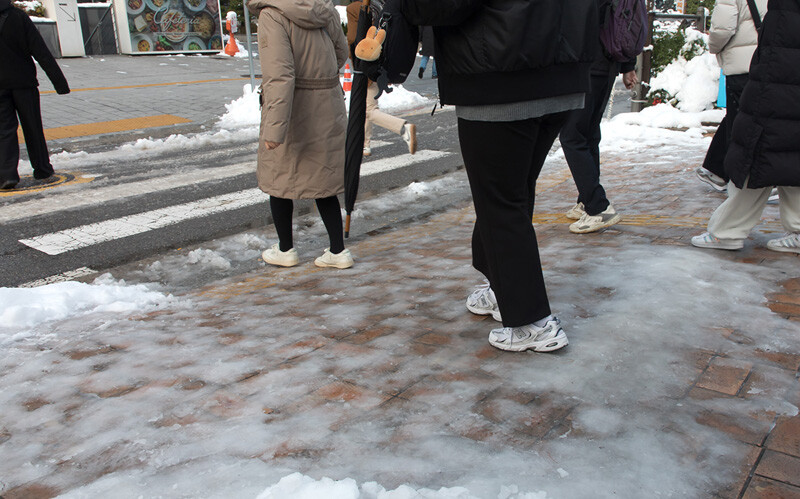 얼어붙은 국회 앞 횡단보도를 조심조심 건너는 시민들.