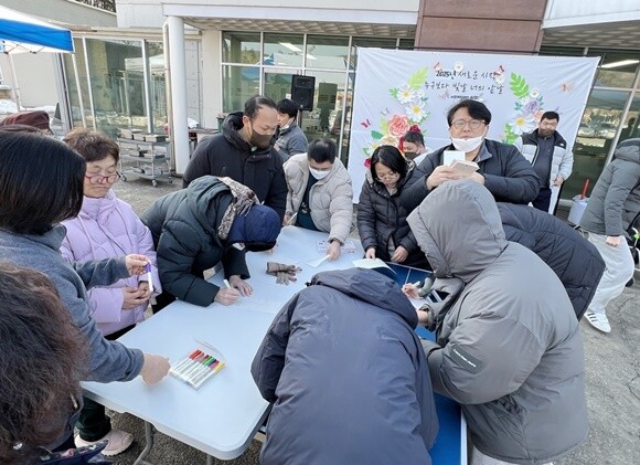 달집에 매달 소원지를 쓰는 참석자들. 사진=씨엘의집 제공