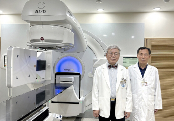 류성열 암병원장과 강위생 과장이 ‘꿈의 암 치료기’로 알려진 ‘라이낙(LINAC)’ 앞에서 암 치료 2만 건 돌파 기념촬영을 갖고 있다. 사진=온병원 제공