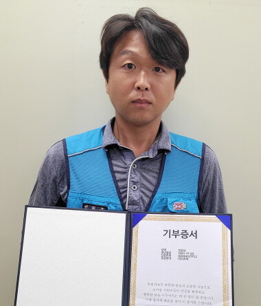 창원우체국 민원규 집배원이 머리카락 기부 후 기부증서를 들고 있는 모습. 사진=부산지방우정청 제공