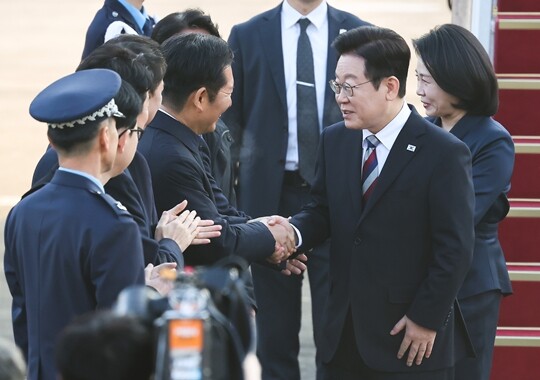 이재명 대통령과 부인 김혜경 여사가 2025년 11월 26일 경기 성남 서울공항에 도착해 공군1호기에서 내려 정청래 대표와 인사하고 있다. 사진=임준선 기자