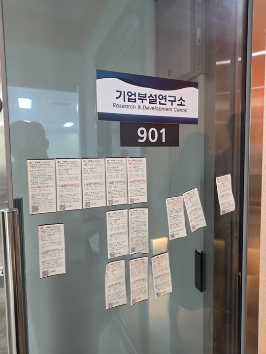 2025년 8월 폐쇄된 위치커머스 경기 김포 사무실 입구 유리문에 피해자들이 보낸 내용증명 통지서가 붙어있다. 위치커머스 상호가 아닌 '기업부설연구소' 상호가 붙어있어 또 다른 의문을 자아낸다. 사진=독자 제공