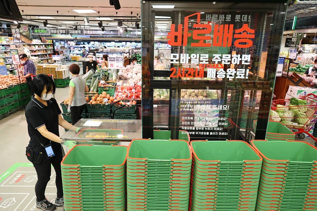 서울 노원구의 한 롯데마트 매장에서 직원이 온라인 주문 상품을 장바구니에 담아 집하장과 연결된 레일로 보내기 위해 리프트에 싣고 있다. 사진=연합뉴스