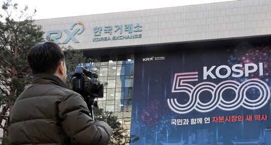정부와 여당이 한국거래소를 지주회사 체제로 전환하고 코스닥 시장을 별도 자회사로 분리하는 방안을 추진하면서 찬반 논쟁이 거세지고 있다. 1월 23일 서울 여의도 한국거래소 서울사옥 건물에 ‘코스피 5000’ 경신을 축하하는 대형 현수막이 붙어 있다. 사진=박정훈 기자