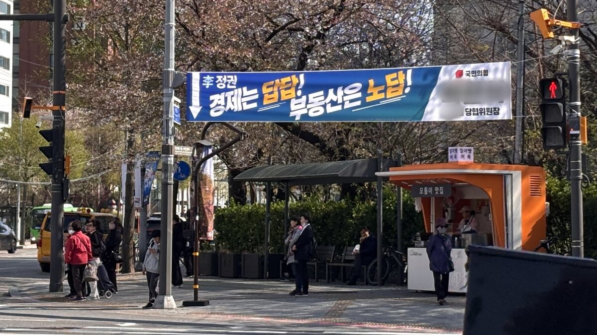 지난 8일 서울 노원구의 한 거리에 걸린 국민의힘 소속 지역 정치인 게시 현수막. 파란색 바탕에 흰색·노란색 글씨로 문구가 적혀있다. 당명(로고)만 자당 상징색인 빨간색으로 작게 표시된 것이 보인다. 사진=윤채현 인턴기자