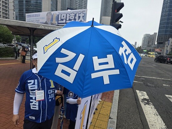 우산을 쓰고 선거운동하는 김부겸 캠프 선거운동원들. 사진=이동섭 기자