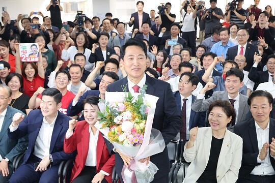 국민의힘 오세훈 서울시장 당선인이 6월 4일 서울 종로구 대왕빌딩에 마련된 선거사무소에서 입장을 밝힌 뒤 꽃다발을 들고 인사하고 있다. 사진=임준선 기자