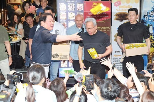 젠슨 황 엔비디아 최고경영자(CEO)가 6월 5일 서울 마포구 홍대 인근 삼겹살 음식점 '형님 저요'에서 최태원 SK그룹 회장 등과 '삼소(삼겹살·소주) 회동’을 하며 도넛이 담긴 도시락 상자를 시민들에게 나눠주고 있다. 사진=임준선 기자