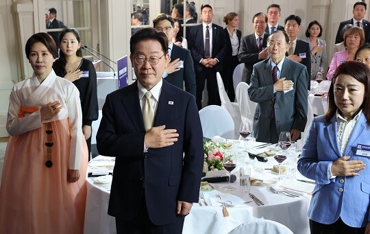이재명 대통령과 김혜경 여사가 6월 9일(현지시각) 벨기에 브뤼셀 한 호텔에서 열린 동포 만찬간담회에서 국기에 경례하고 있다. 사진=연합뉴스