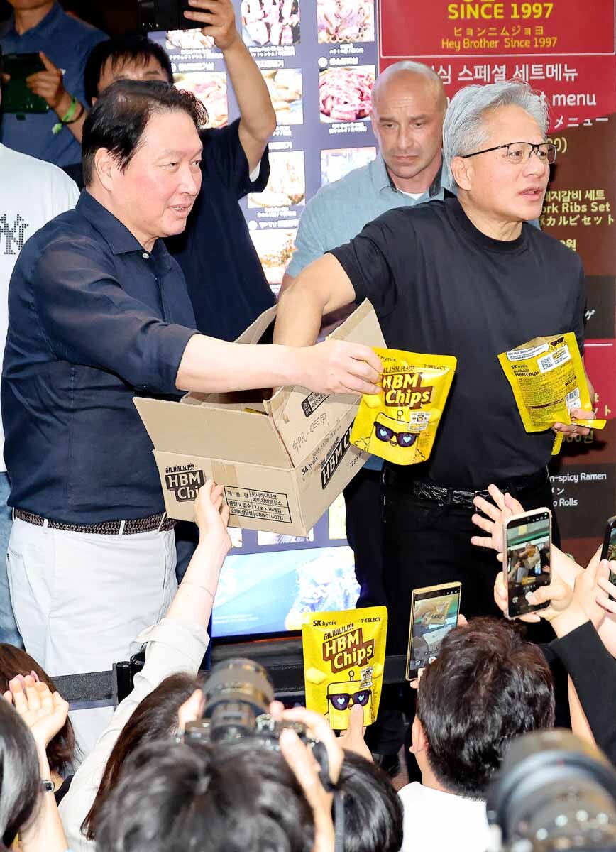 젠슨 황 CEO와 최태원 회장이 삼겹살 음식점 앞에서 HBM 과자를 나눠주고 있다. 사진=임준선 기자