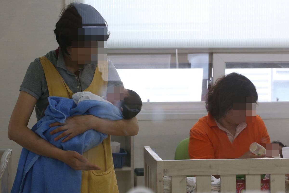 입양을 기다리고 있는 아동들을 자원봉사자들이 돌보고 있는 모습. 사진=연합뉴스