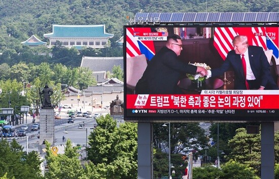 2018년 6월 12일 광화문 앞 전광판에 도널드 트럼프 미국 대통령과 김정은 북한 국무위원장이 만난 장면이 생중계되는 화면. 사진=최준필 기자