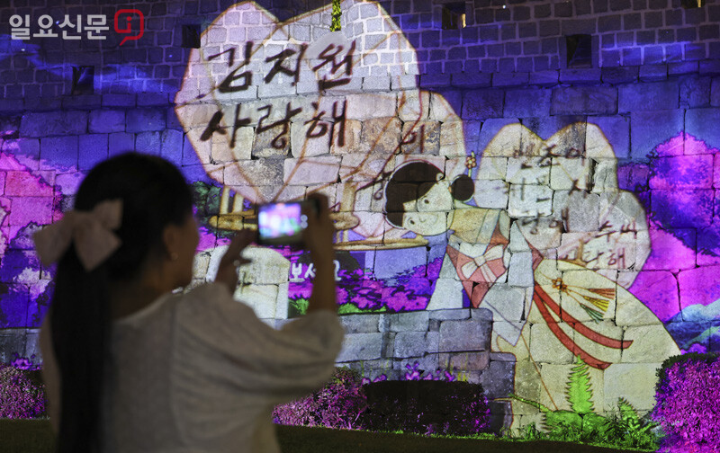 자신의 염원을 적은 메모가 펼쳐진 미디어아트를 시민들이 촬영하고 있다. 사진=박정훈 기자