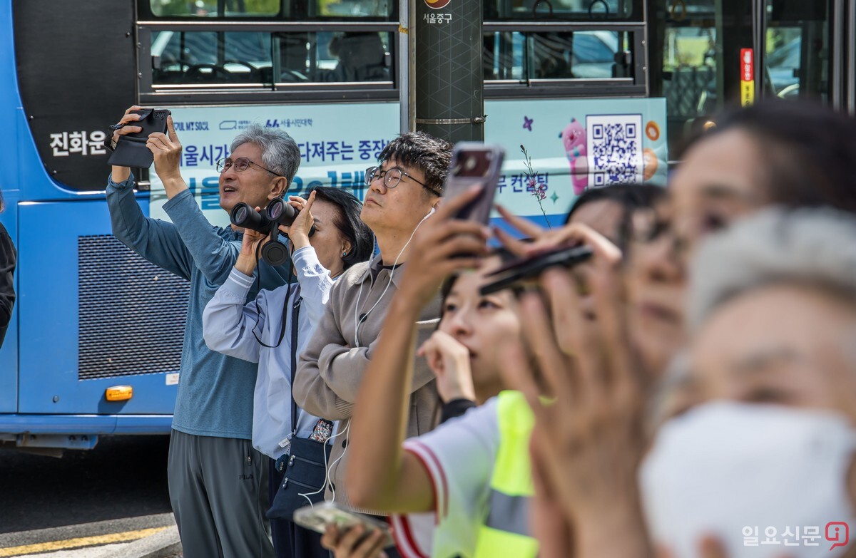 시민들이 얀 루스의 고공 퍼포먼스를 지켜보고 있다. 이날 루스는 코리아나호텔과 동아미디어센터를 잇는 지상 약 120m 높이, 편도 160m 구간의 슬랙라인 횡단에 나섰다. 사진=최준필 기자