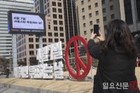 서울시장보궐선거 참여 캠페인 전광판과 설치물을 촬영하는 시민